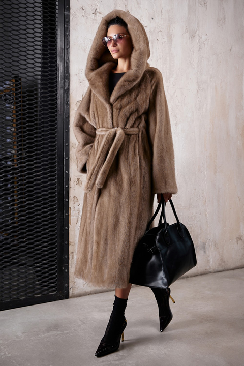Light brown long mink fur coat with hood and belt at the waist, showcasing luxury and elegance.