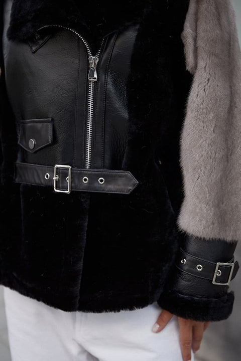 Close up of a leather jacket with grey mink sleeves. 