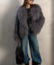 A woman wearing a beautifully handcrafted grey Mongolian coat made from the thickest, softest 100% genuine Mongolian fur, featuring a dramatic collar, long sleeves, snap closures, and a luxurious satin and leather inner lining.