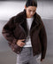 A woman wearing a classic brown aviator leather bomber jacket crafted from heavyweight sheepskin, featuring cozy shearling lining and a cropped, feminine twist on a sporty oversized style.
