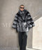 Model dressed in a luxurious silver fox fur coat, featuring oversized proportions and a sleek leather belt for timeless sophistication.