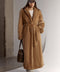 A woman wears a full-length mink fur coat in a rich, natural tone, showcasing timeless elegance and luxurious warmth.