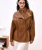 A woman wears the Simona Genuine Leather Jacket very elegantly, showcasing its sporty yet chic design with a high neck and relaxed fit.